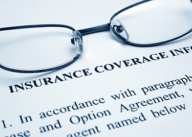 Black-framed glasses at the top of an insurance coverage form