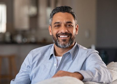 Man smiling while sitting in couch at home