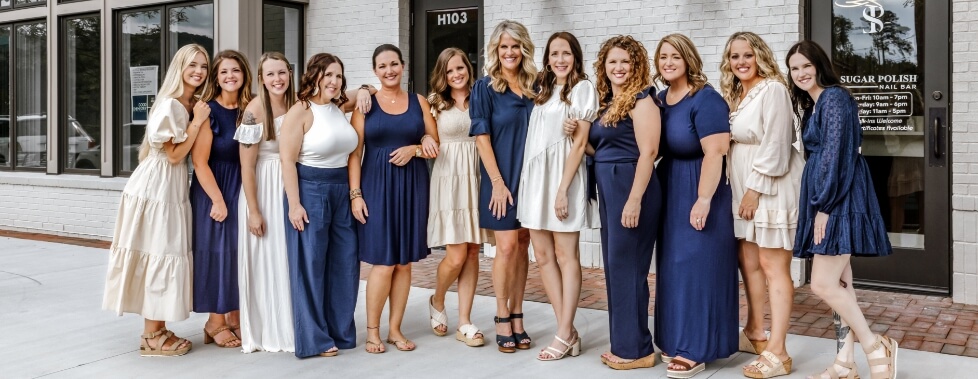 Bragg Dental team members wearing tan and dark blue dresses