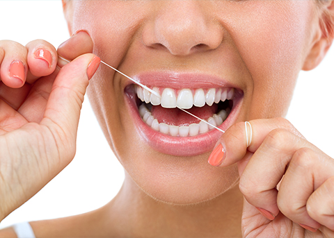 Close up of a person flossing their teeth