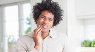 Wincing man holding his jaw in pain