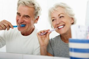 Older adults brushing their teeth to prevent gum disease