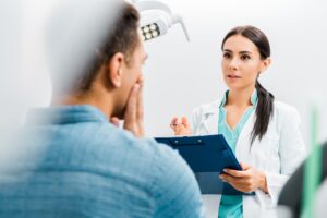 Concerned-looking dentist conversing with patient.